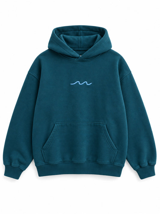 Front view of the Ocean Pulse deep teal puff print hoodie with a small pale-blue wave at the center chest