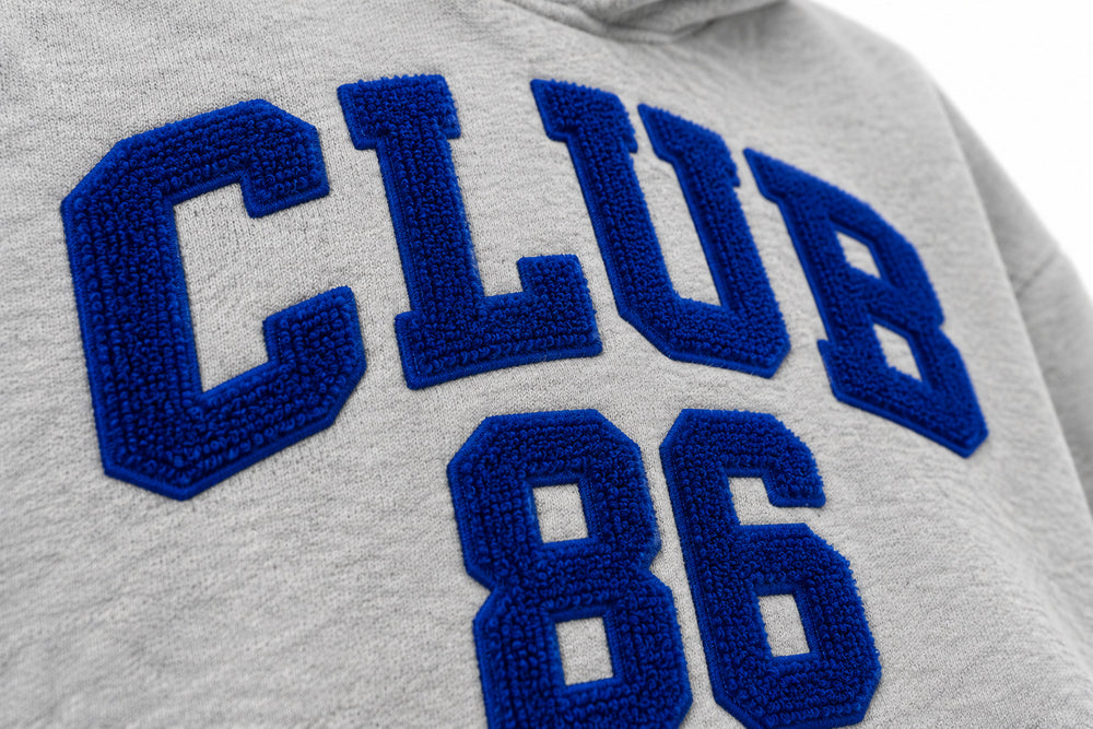 Close-up of the chenille decoration on the Club 86 heather gray chenille boxy hoodie