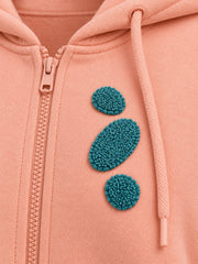 Close-up of the chenille decoration on the Pebble Stack peach chenille cropped zip-up hoodie