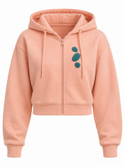Front view of the Pebble Stack peach chenille cropped zip-up hoodie with three teal chenille pebble patches stacked on the left chest