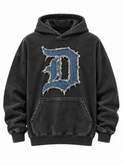 Front view of the Denim Letter washed black denim appliqué oversized hoodie with oversized blue denim D monogram with a frayed edge and cream stitched border