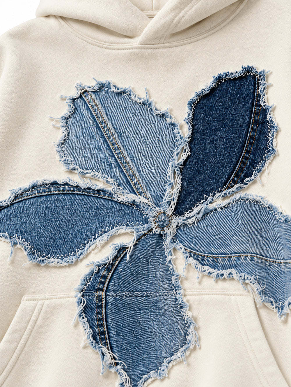 Close-up of the denim appliqué decoration on the Denim Petals cream denim appliqué oversized hoodie