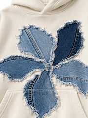 Close-up of the denim appliqué decoration on the Denim Petals cream denim appliqué oversized hoodie