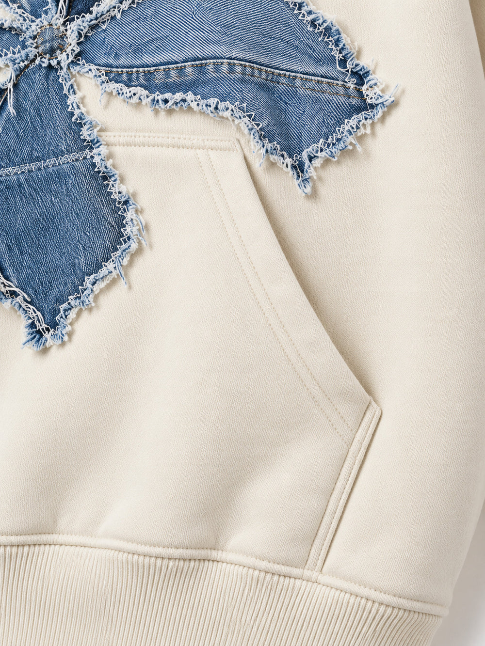 Close-up of the seam stitching of the Denim Petals cream denim appliqué oversized hoodie