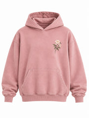 Front view of the Bloom Season faded pink DTG print oversized hoodie with small cream flower sprig