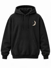 Front view of the Lunar Voyage black DTG print oversized hoodie with small cream moon on the left chest