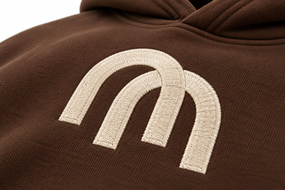 Close-up of the embroidered decoration on the Arc Atelier chocolate brown embroidered boxy hoodie