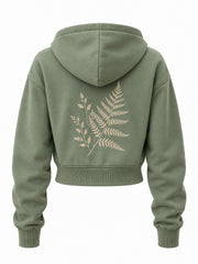 Back view of the Botanical Zip sage embroidered cropped zip-up hoodie with larger cream fern embroidered below the hood