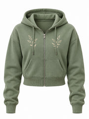 Front view of the Botanical Zip sage embroidered cropped zip-up hoodie with two small cream botanical sprigs embroidered either side of the zipper