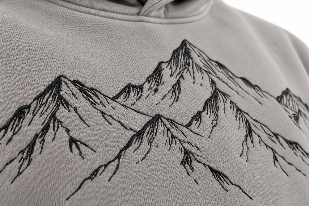 Close-up of the embroidered decoration on the Contour Club stone gray embroidered oversized hoodie