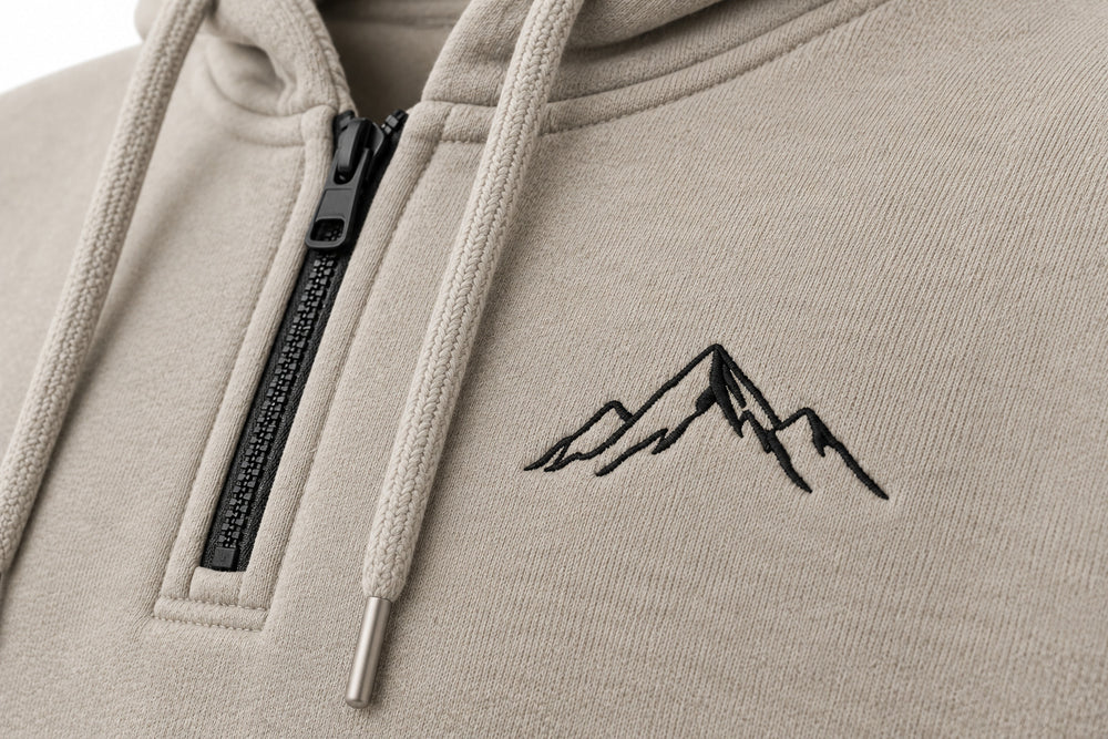 Close-up of the embroidered decoration on the Contour Half Zip stone embroidered boxy half-zip hoodie