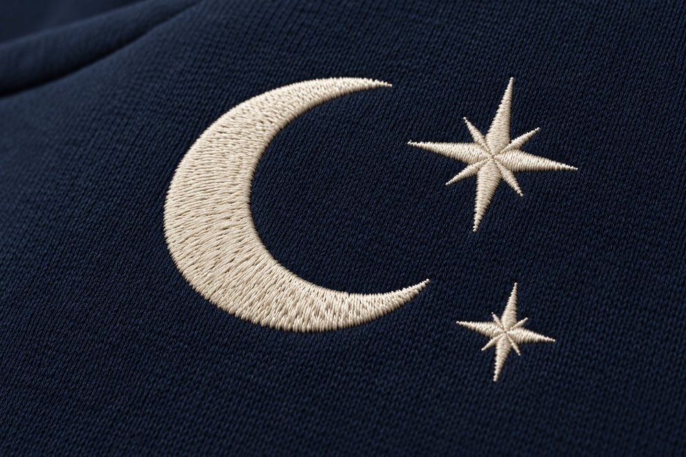 Close-up of the embroidered decoration on the Crescent Studio midnight navy embroidered boxy hoodie