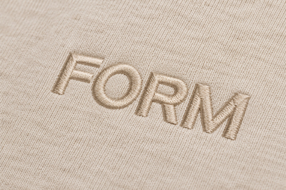 Close-up of the embroidered decoration on the Quiet Form oatmeal embroidered oversized hoodie