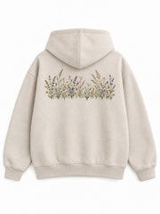 Back view of the Wild Meadow oatmeal embroidered hoodie with a horizontal embroidered wildflower meadow