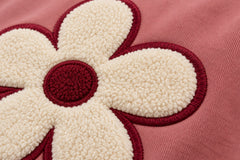 Close-up of the felt appliqué decoration on the Felt Bloom dusty rose felt appliqué hoodie