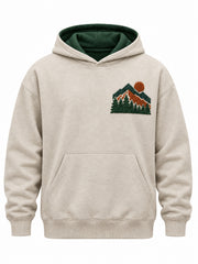 Front view of the Mountain Patch oatmeal felt appliqué hoodie with layered forest and rust felt mountain patch on the left chest