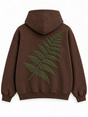 Back view of the Velvet Fern chocolate brown flock print boxy hoodie with a larger green flocked fern