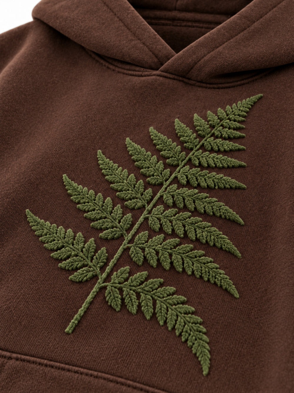 Close-up of the flock print decoration on the Velvet Fern chocolate brown flock print boxy hoodie
