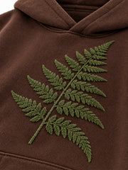 Close-up of the flock print decoration on the Velvet Fern chocolate brown flock print boxy hoodie