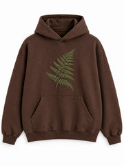 Front view of the Velvet Fern chocolate brown flock print boxy hoodie with a green velvet-flock fern across the chest