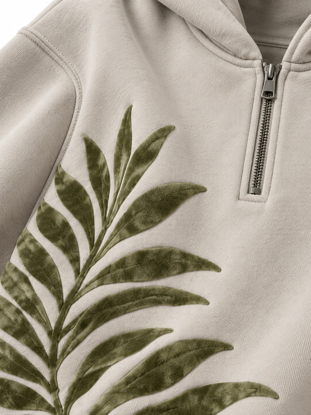 Close-up of the flock print decoration on the Palm Frond stone flock print quarter-zip hoodie