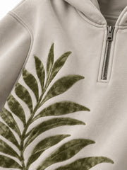 Close-up of the flock print decoration on the Palm Frond stone flock print quarter-zip hoodie