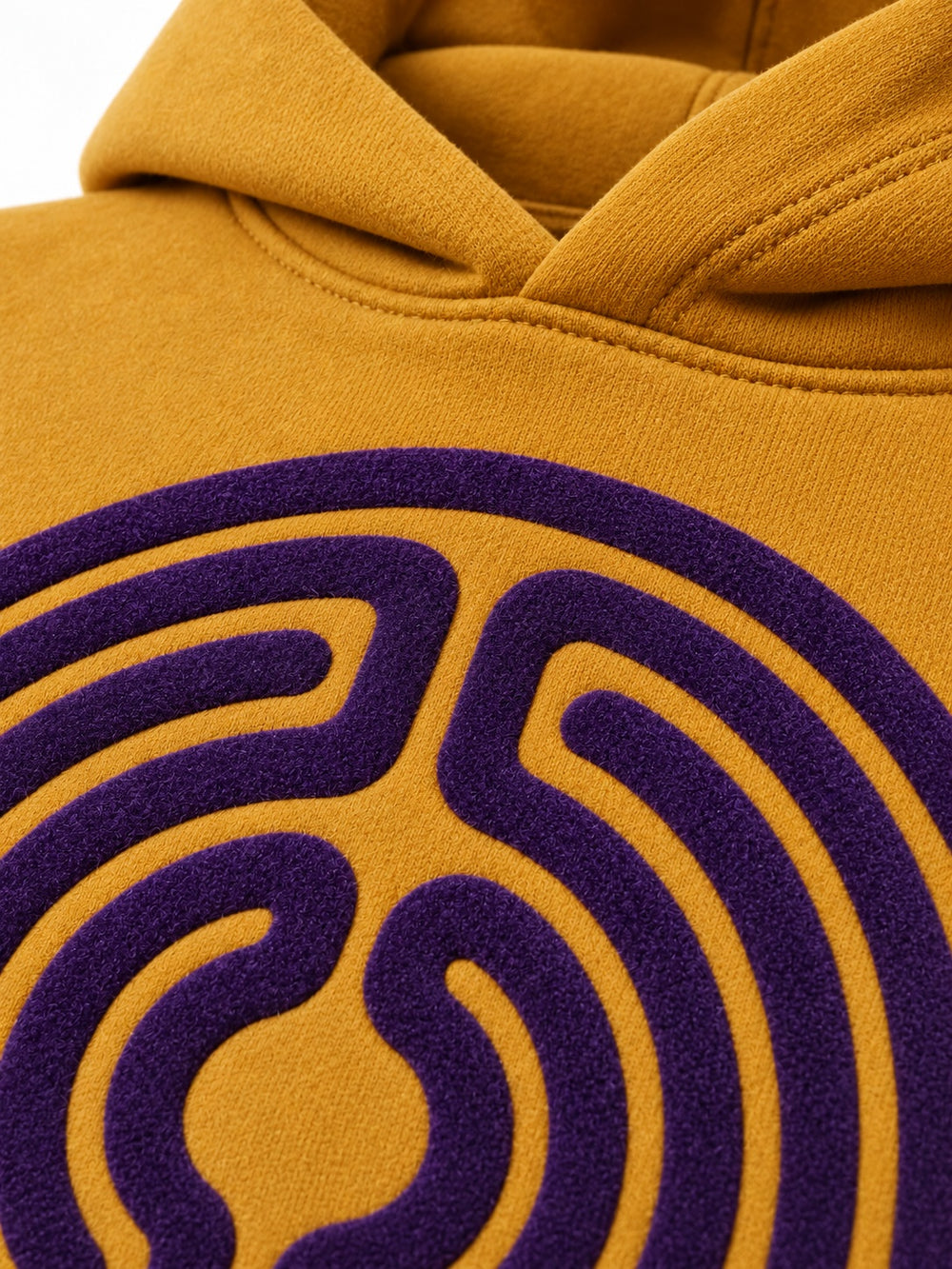 Close-up of the flock print decoration on the Velvet Maze ochre flock print boxy hoodie