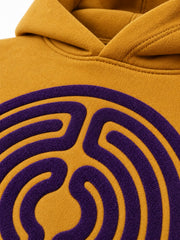 Close-up of the flock print decoration on the Velvet Maze ochre flock print boxy hoodie