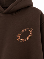Close-up of the foil print decoration on the Copper Orbit espresso brown foil print oversized hoodie