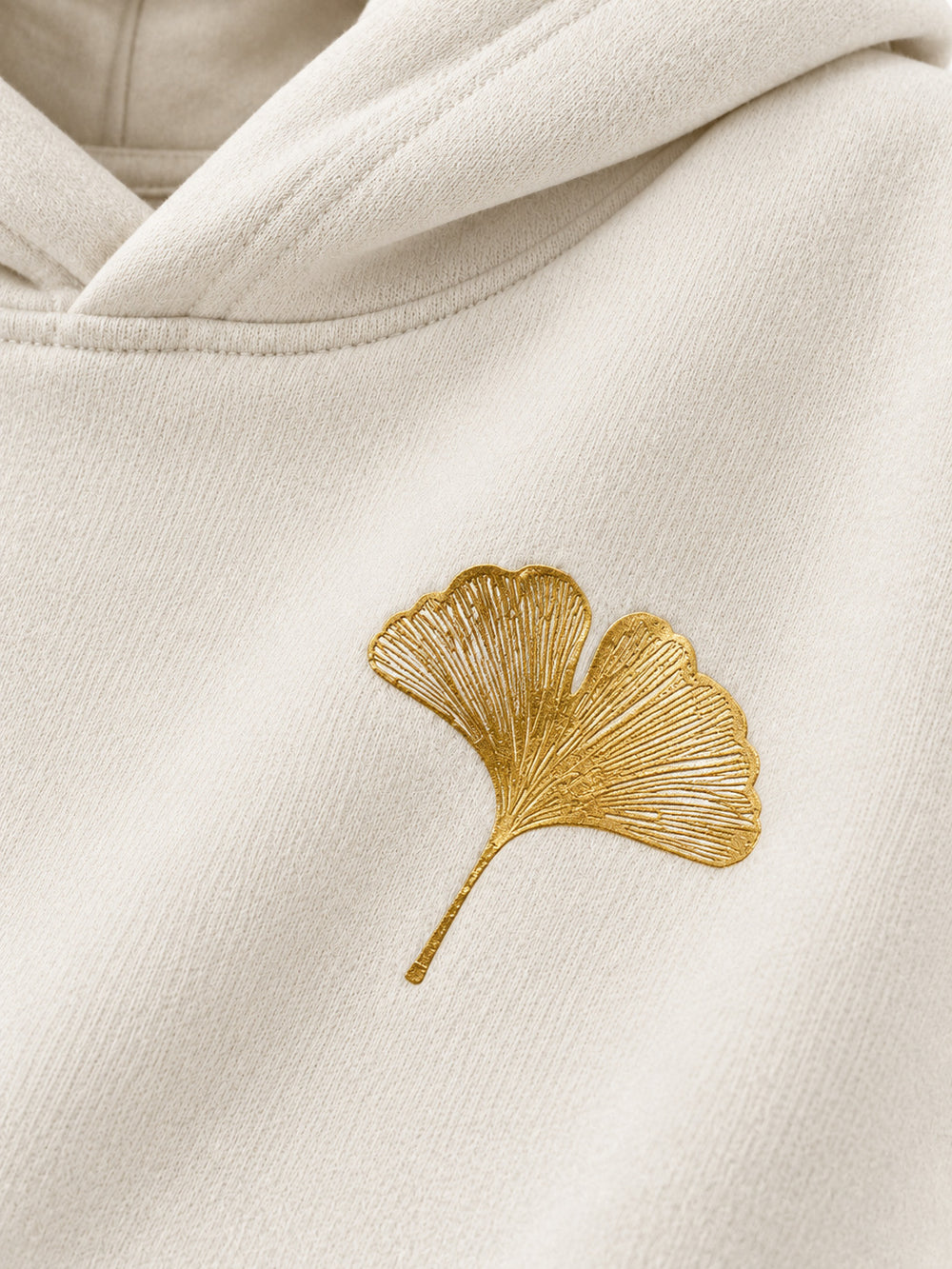 Close-up of the foil print decoration on the Gold Ginkgo cream foil print hoodie