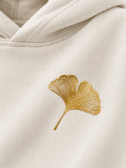 Close-up of the foil print decoration on the Gold Ginkgo cream foil print hoodie