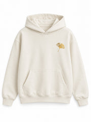 Front view of the Gold Ginkgo cream foil print hoodie with a small gold-tone ginkgo-leaf motif at the left chest