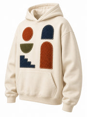 Front three-quarter view of the Patchwork Studio cream patchwork appliqué boxy hoodie