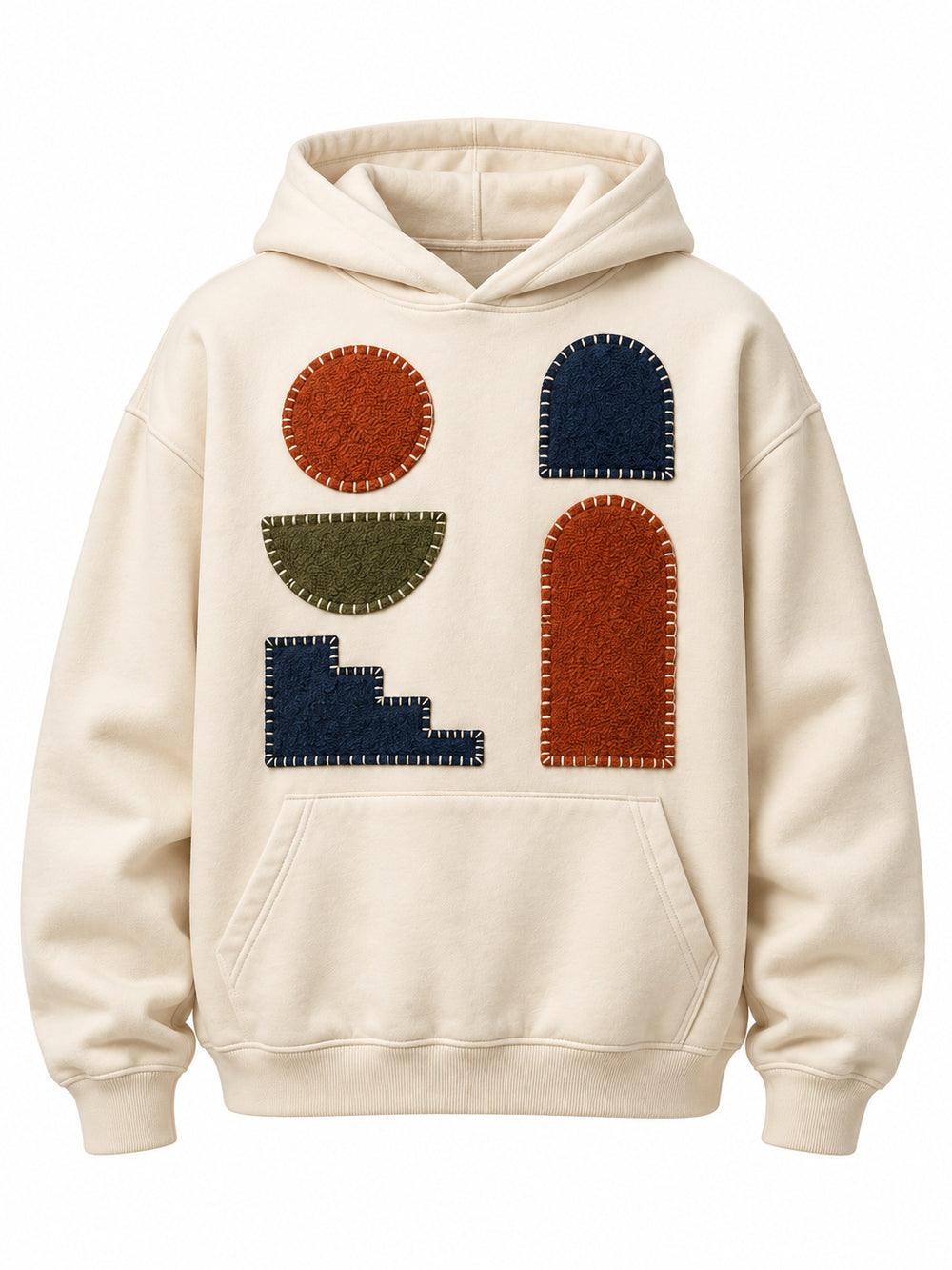 Front view of the Patchwork Studio cream patchwork appliqué boxy hoodie with rust, navy and moss geometric fabric patches with visible blanket stitching