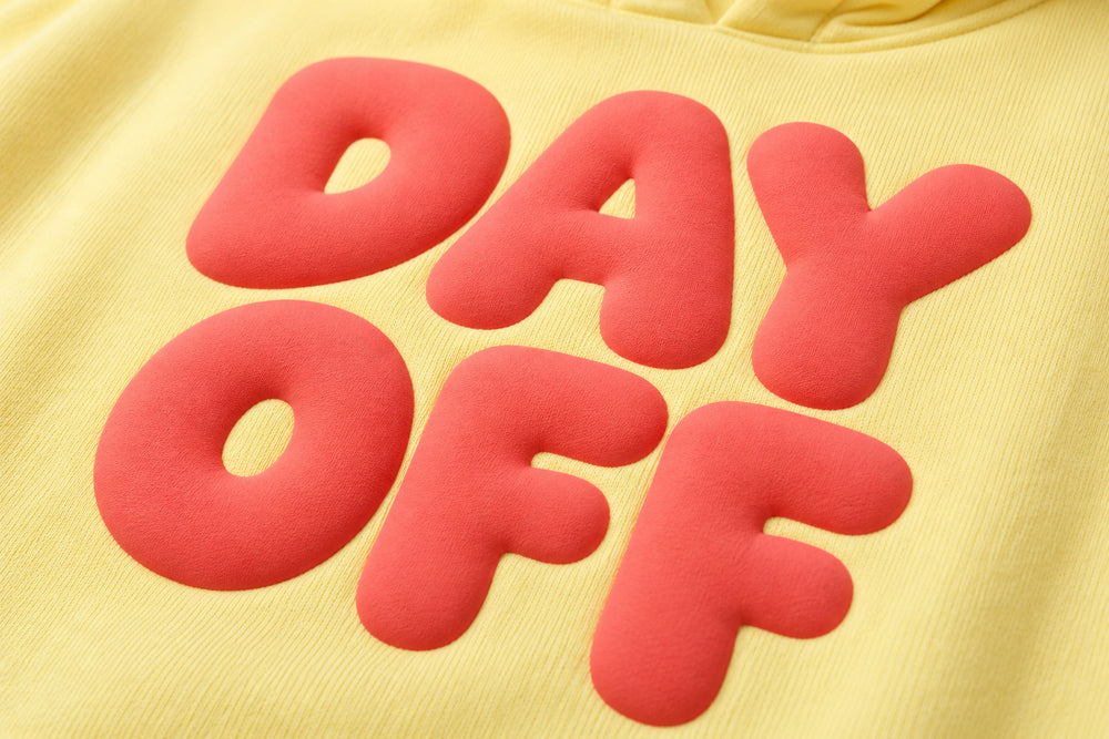 Close-up of the puff print decoration on the Day Off butter yellow puff print hoodie