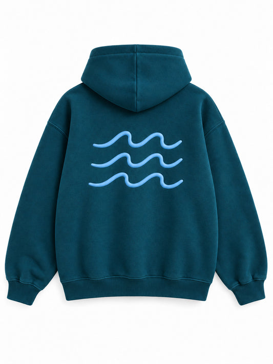 Back view of the Ocean Pulse deep teal puff print hoodie with three pale-blue rows of rolling waves