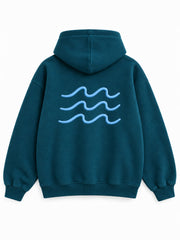 Back view of the Ocean Pulse deep teal puff print hoodie with three pale-blue rows of rolling waves