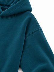 Close-up of the sleeve of the Ocean Pulse deep teal puff print hoodie