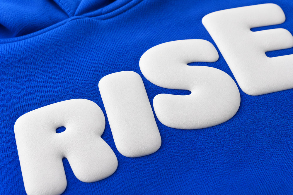 Close-up of the puff print decoration on the Rise cobalt blue puff print boxy hoodie