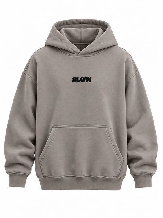 Front view of the Slow Motion warm gray puff print oversized hoodie with small black SLOW puff print above the pocket