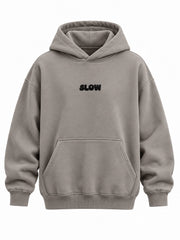 Front view of the Slow Motion warm gray puff print oversized hoodie with small black SLOW puff print above the pocket