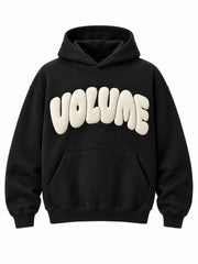 Front view of the Volume black puff print oversized hoodie with large cream VOLUME lettering in puff print above the pocket