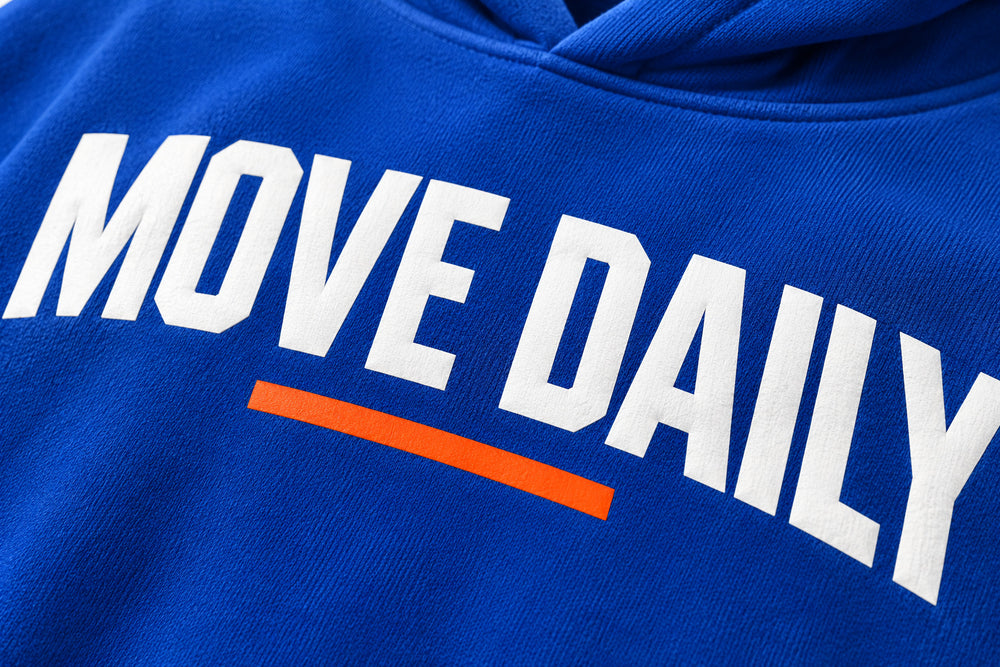 Close-up of the screen print decoration on the Move Daily cobalt blue screen print hoodie