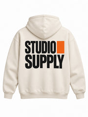 Back view of the Studio Supply ecru screen print boxy hoodie with large black stacked STUDIO SUPPLY type grid with one orange square