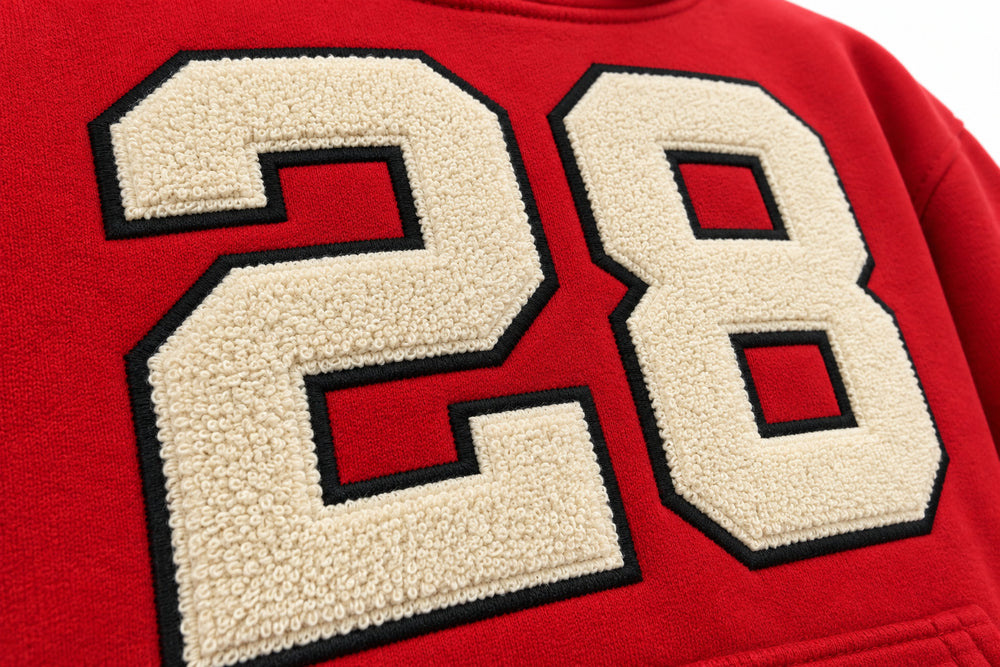 Close-up of the twill appliqué decoration on the Racing Twill red twill appliqué boxy hoodie