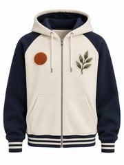 Front view of the Sun Sprig cream and navy chenille zip-up hoodie with rust chenille sun disc on the left chest and an embroidered leaf-sprig patch