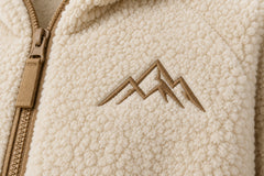 Close-up of the woven patch decoration on the Polar Zip cream woven patch zip-up hoodie